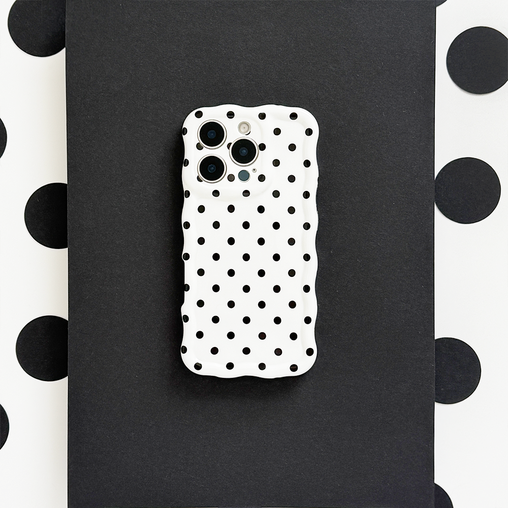 Wavy phone case in white with black polka dots, displayed on a matching black and white polka dot background.