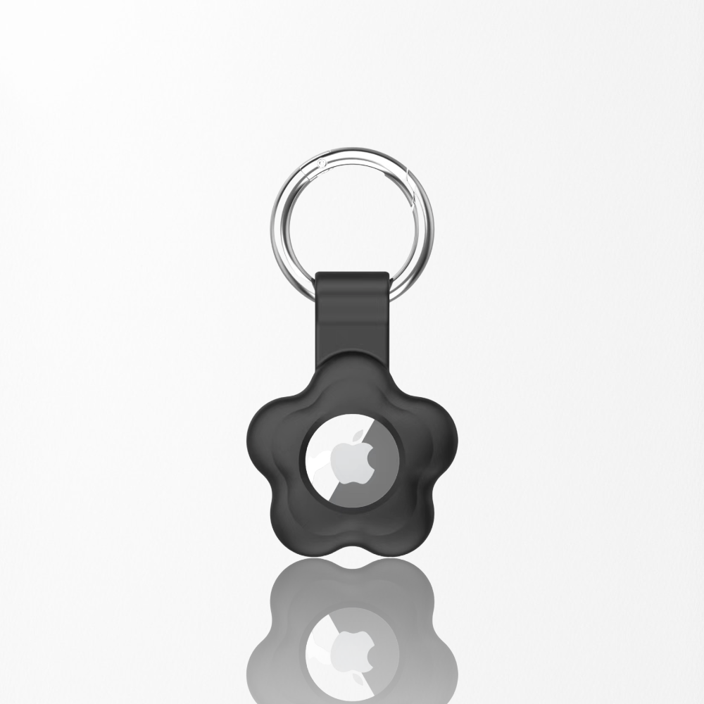 A black flower-shaped keychain holder with an Apple AirTag inside, featuring a silver key ring, displayed on a white background.