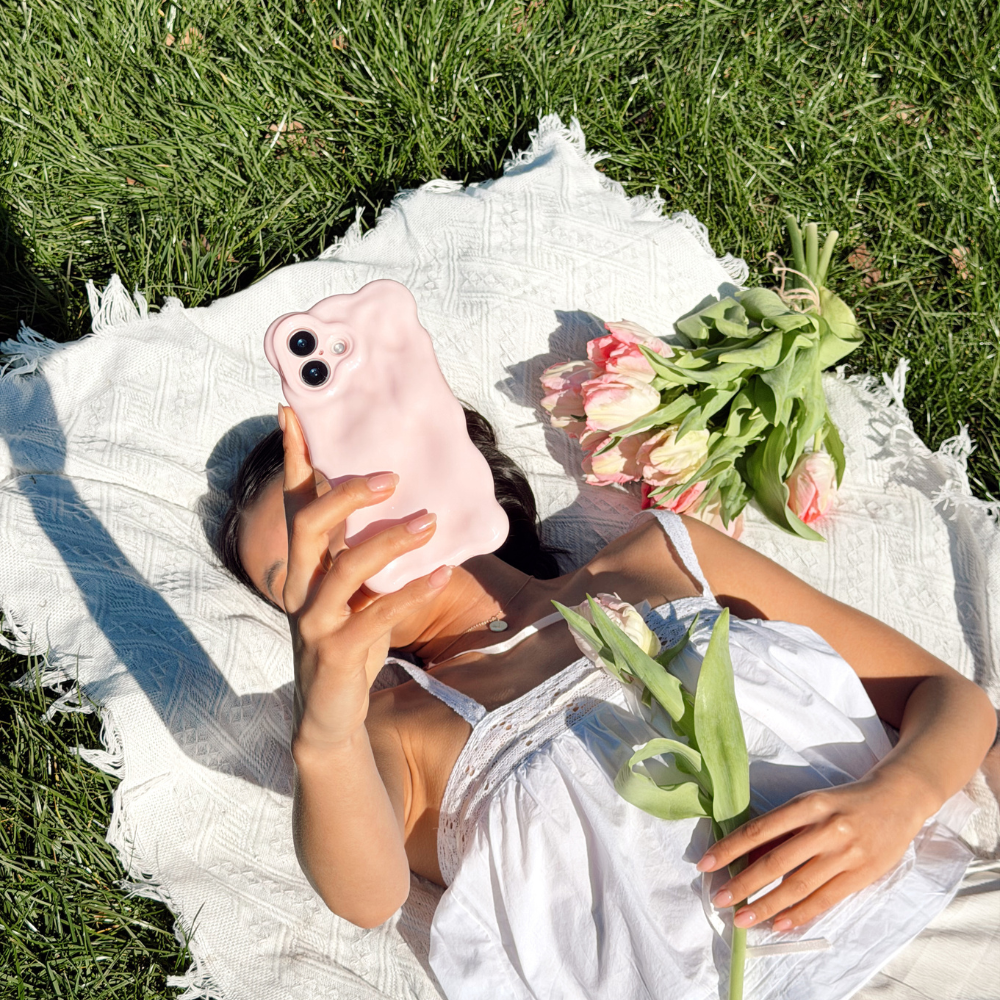 Girl at a picnic with flowers close up image taking a selfie of the 3D Bubble Phone Case in Powder Pink