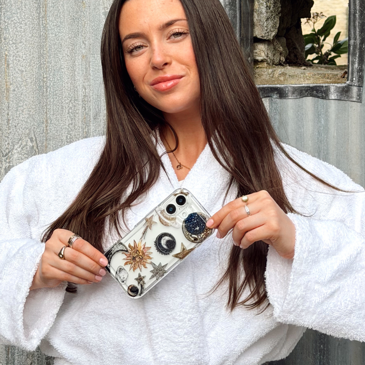 Girl in outdoor shower setting holding celestial phone case