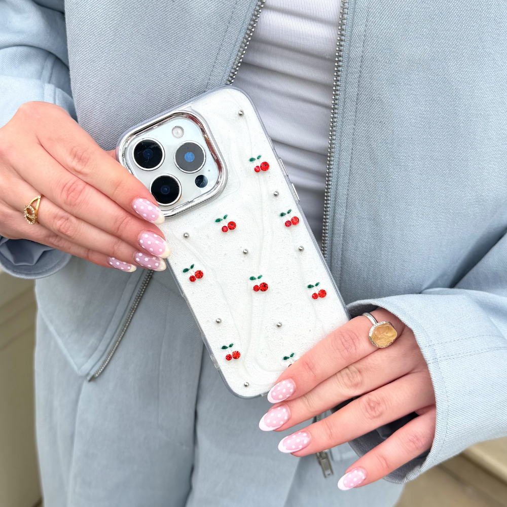 Girl holding cherry pearl phone case wearing blue outfit