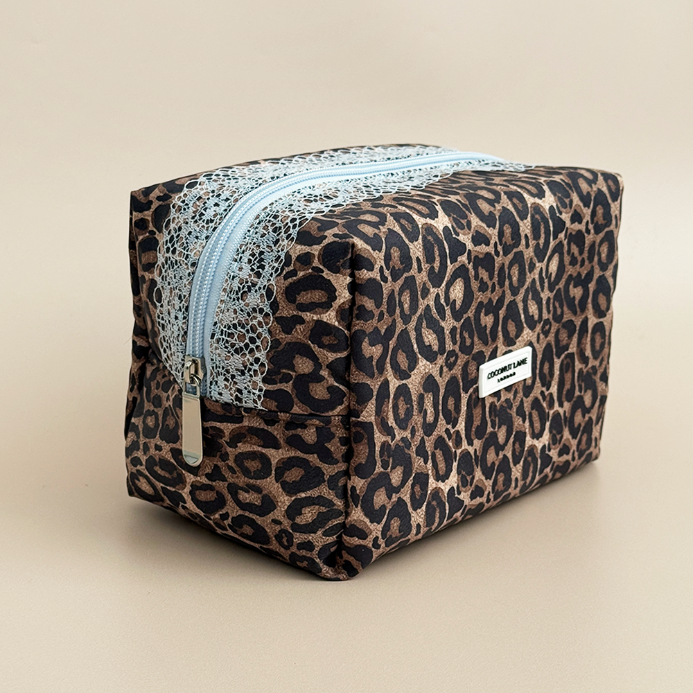 Angled view of Coconut Lane Leopard Lace makeup bag with brown leopard print, delicate baby blue lace trim and zip closure.