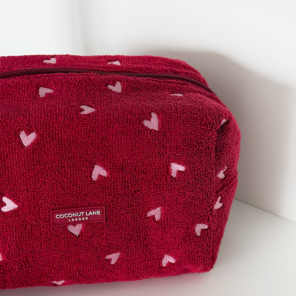 Red pouch with heart patterns and Coconut Lane label on a white background