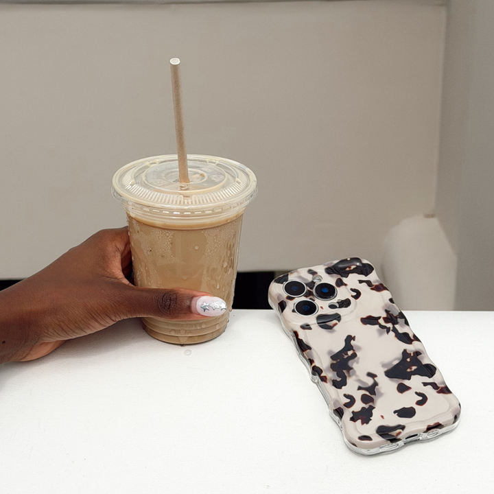 Girl with wavy ivory tort phone case and iced coffee