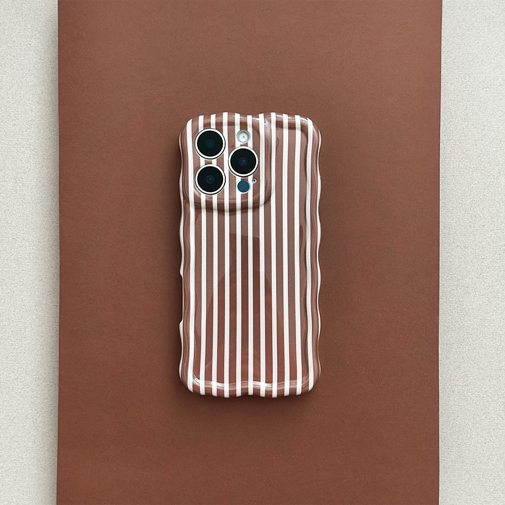 Coconut Lane wavy phone case with chestnut brown stripes on a flat brown surface.