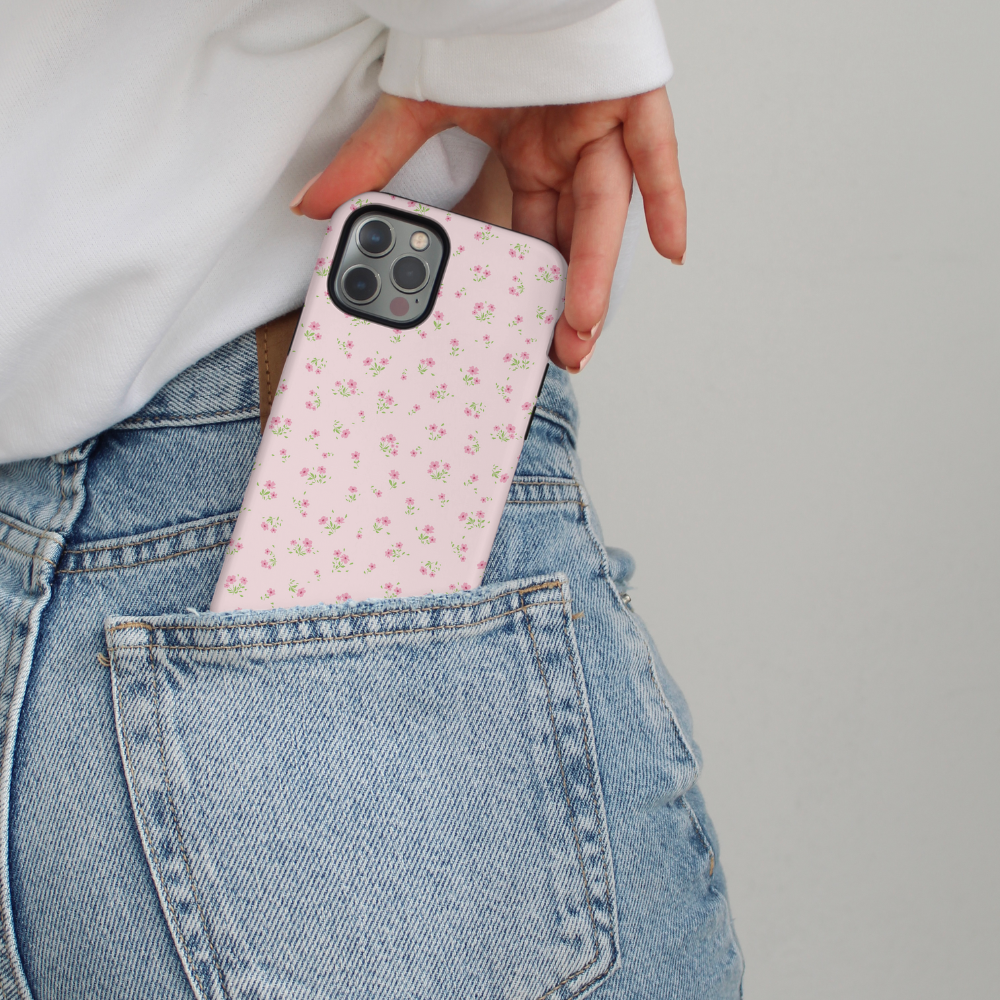 A pink phone in a Coconut Lane Ditsy Floral Tough Case is slipped into the back pocket of blue jeans.
