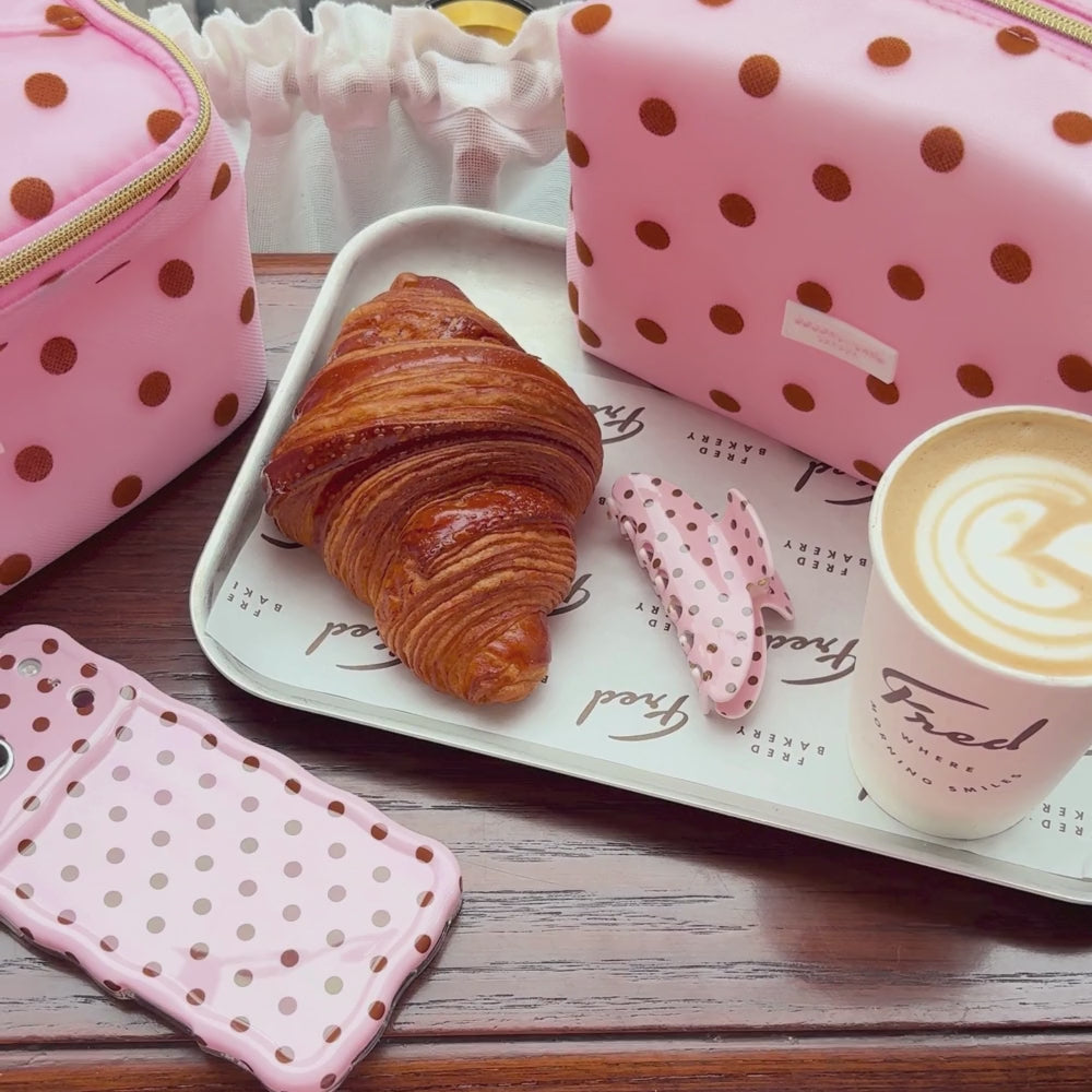 Dot Society pink and brown collection. Including the wavy phone case, pink and brown polka dot claw clip, with a matching makeup bag and vanity case. 